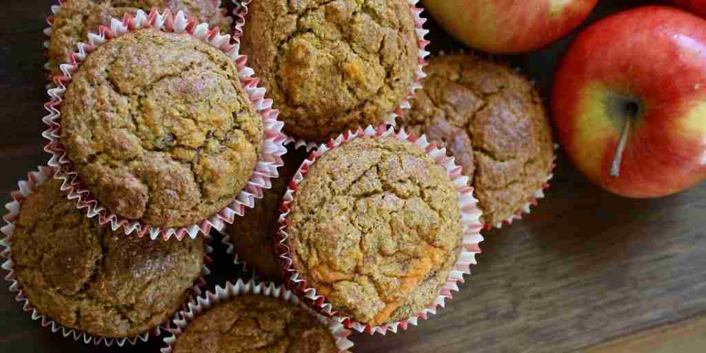 Muffins μήλων σε χαρτιά muffin? κόκκινα μήλα